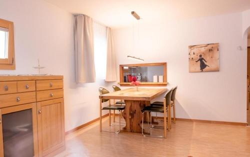 錫爾斯瑪利亞的住宿－Chesa La Capriola，一间带木桌和椅子的用餐室