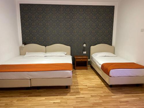 - deux lits assis l'un à côté de l'autre dans une pièce dans l'établissement Hotel Fenicia, à Rome