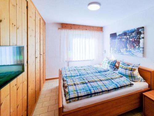 a bedroom with a bed and a flat screen tv at Curtins16 in Pontresina