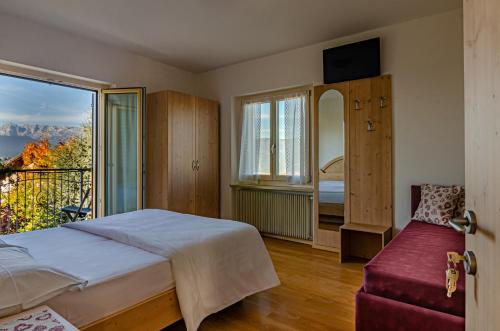 a bedroom with a bed and a balcony at Agritur Cristina in Coredo