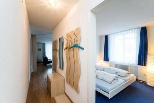 Habitación con cama y sofá con tabla de surf en la pared en Chesa Quadrella, en Pontresina