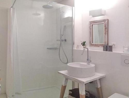 een witte badkamer met een wastafel en een douche bij Chesa Auricula in Pontresina