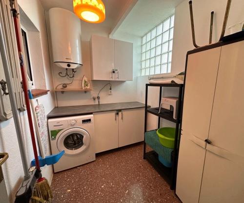 a kitchen with a washing machine and a sink at Bel Appartement vue Mer in Roses