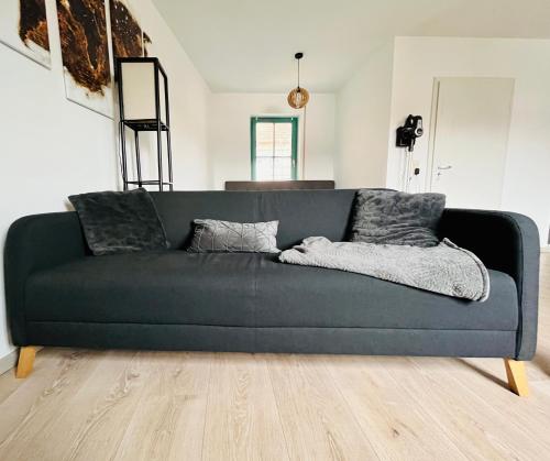 a blue couch sitting in a living room at Das Chorzimmer- Ambiente am Fuße der Burg in Holzhausen