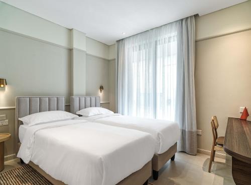 Ліжко або ліжка в номері LIV Mackenzie Beach Suites Larnaca ADULTS ONLY