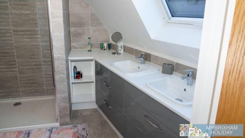 W łazience znajduje się umywalka i prysznic. w obiekcie 3 Ocean Gate w mieście Brixham