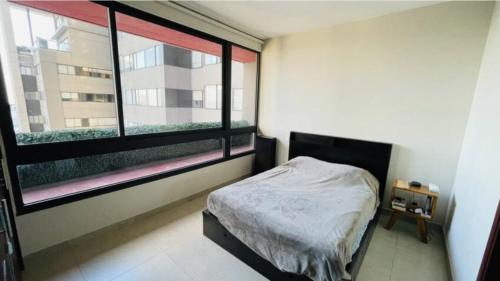 - une chambre avec un lit et une grande fenêtre dans l'établissement Amplio Departamento 2 Recamaras, à Mexico