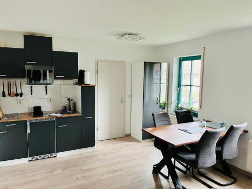 eine Küche und ein Esszimmer mit einem Tisch und Stühlen in der Unterkunft Das Chorzimmer- Ambiente am Fuße der Burg in Holzhausen