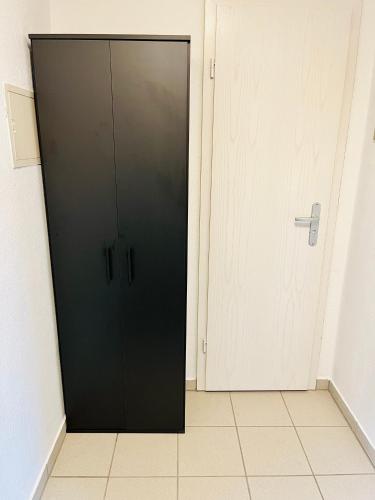 a black cabinet in a room next to a door at Das Chorzimmer- Ambiente am Fuße der Burg in Holzhausen