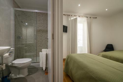 a bedroom with a shower and a toilet and a sink at Hospedaria Santa Maria in Beja