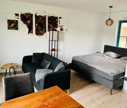 ein Wohnzimmer mit einem Bett und einem Sofa in der Unterkunft Das Chorzimmer- Ambiente am Fuße der Burg in Holzhausen