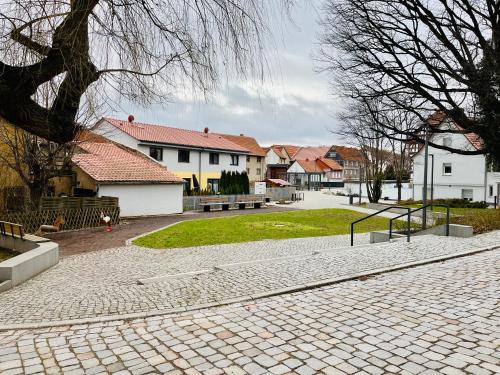 a cobblestone street with houses and a park with benches at Das Chorzimmer- Ambiente am Fuße der Burg in Holzhausen