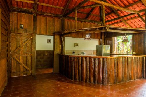 a kitchen with a bar in a wooden building at La Fortuna Natural Green in Fortuna