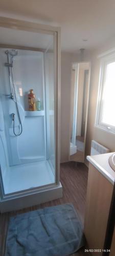 a bathroom with a shower with a glass door at Mobil home 2 chambres tout équipé in Hourtin