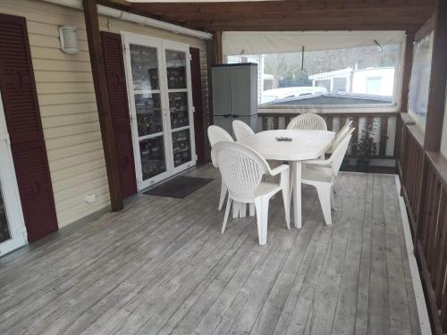 a porch with a table and chairs on a deck at Mobil home 2 chambres tout équipé in Hourtin