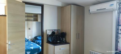 a room with a closet and a bedroom with a bed at Mobil home 2 chambres tout équipé in Hourtin