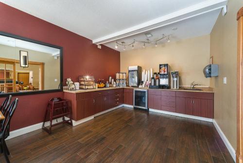 a large kitchen with red walls and wooden floors at Red Roof Inn St Louis - Troy, IL in Troy