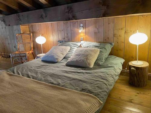 ein Schlafzimmer mit einem Bett mit zwei Kissen und zwei Lampen in der Unterkunft Courchevel 1650 appartement cosy 6 personnes in Courchevel