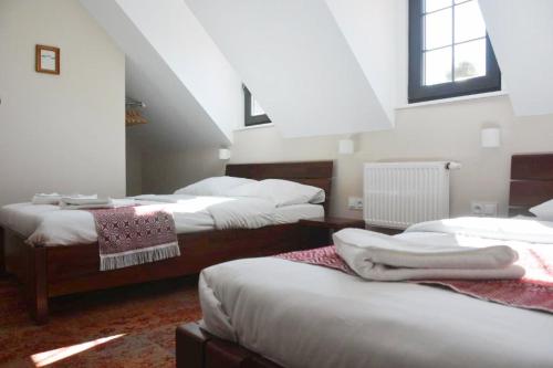 a room with three beds in a attic at Stara Kuźnia Mazurska in Węgorzewo