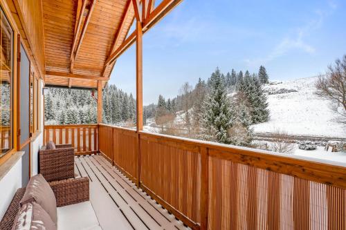 a screened porch with a view of the snow covered mountains at Apartmán Ela in Horní Blatná