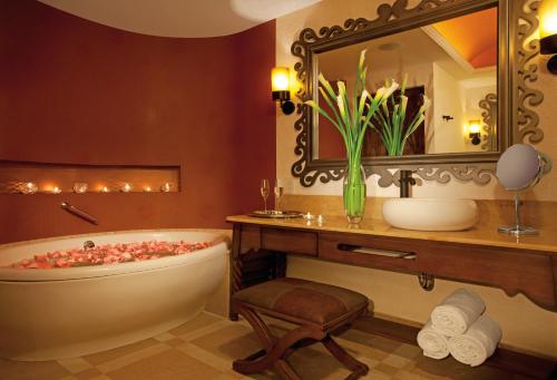 a bathroom with a tub and a sink and a mirror at Secrets Puerto Los Cabos Golf & Spa18+ in San José del Cabo