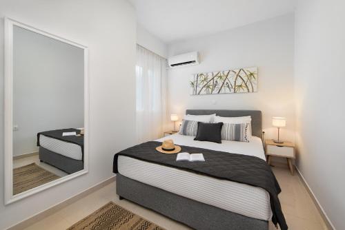 een slaapkamer met een groot bed en een spiegel bij Island Hills in Rhodos-stad
