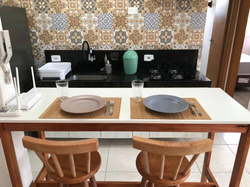 a kitchen with a table with two plates on it at Recanto Salgando a Alma in Ubatuba