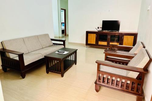a living room with a couch and a tv at TrueLife Comfort Inn - Near PS4 veg restaurant - On way to Balaji Temple - 2BHK AC apartments - Coffee Tea Milk - Fast WiFi, Kitchen, Dining, Android TV, Parking - Easy access to Airport, Railway Station and to all Temples - Top service with lots of Love in Tirupati