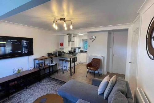 a living room with a couch and a kitchen at Chalet 130 on Glan Gwna holiday park in Caernarfon