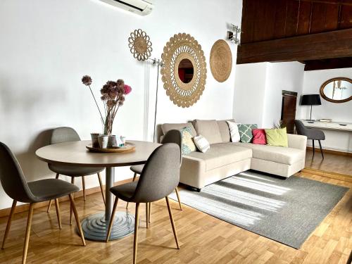 a living room with a table and chairs and a couch at Apart. Palacio Canónigo 7 - Junto Catedral in Toledo