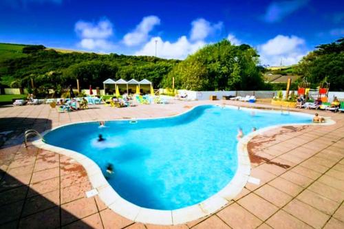 una gran piscina con gente en el agua en Large 4 person Couples and Family Caravan in Newquay Bay Resort en Newquay