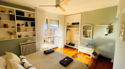 een slaapkamer met een bed en een kamer met een raam bij Casa Carlini Homestay in Getxo