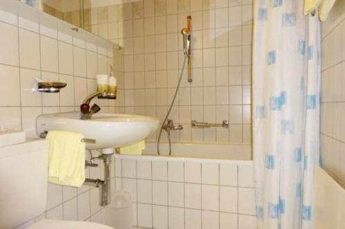 e bagno con lavandino, servizi igienici e vasca. di Apparthotel Pöstli Nr 305 a Maloja