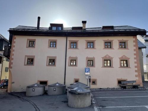 a large building with trash cans in front of it at Chasa Gertz 12-Bett Chasa Engiadina in Sent