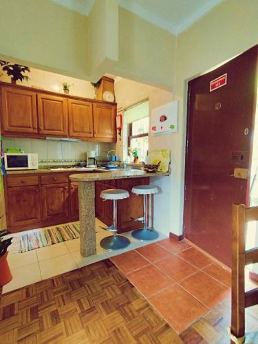 a kitchen with wooden cabinets and a counter with stools at Monteiro's Gerês Countryhouse in Ferral