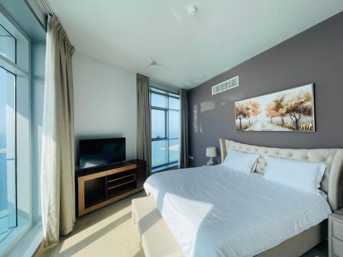 um quarto com uma cama grande e uma televisão em Beachfront paradise just minutes from Dubai em Ajman
