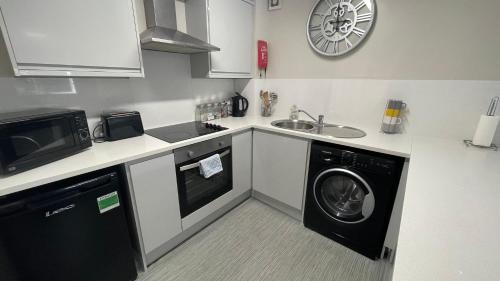 a kitchen with a washing machine and a sink at Hosted By Ryan - 2 Bedroom Apartment in Liverpool