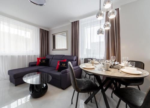 a living room with a blue couch and a table at ApartamentyGdansk eu Mieszkanie Przylesie in Sopot