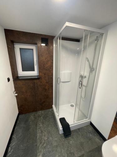 y baño con ducha y puerta de cristal. en Cichy Apartament Gdańsk, en Gdansk