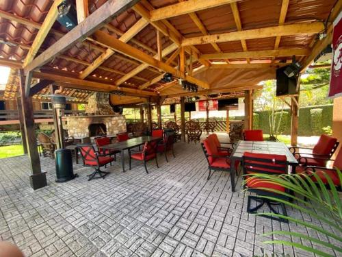 un patio con mesas y sillas y una chimenea en Bama House hn, en Valle de Ángeles