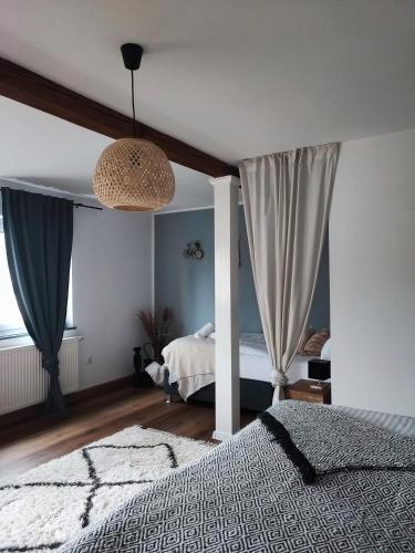 a bedroom with a bed and a chandelier at Elias im Landhausstil in Bayreuth