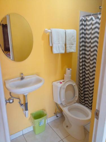 a bathroom with a sink and a toilet and a mirror at Cabañas Martina Surf Playa Guanico in Pedregal