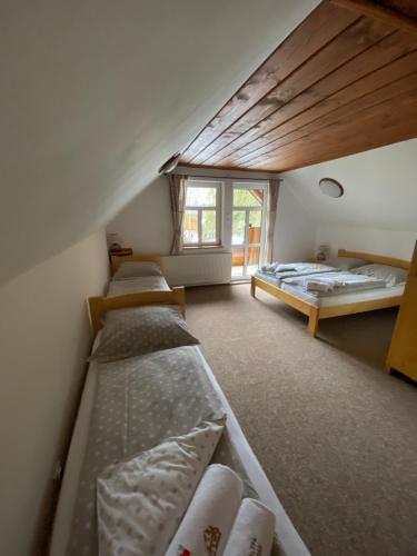 a room with four beds and a window at Chalupa Tomas Jezersko in Vígľaš