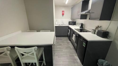 uma pequena cozinha com balcões brancos e bancadas brancas em Hosted By Ryan - 1 Bedroom Apartment em Liverpool