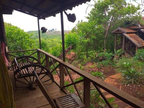 a porch with a bench and a view of a field at Quiet Garden View Lodge&Trekking in Banlung