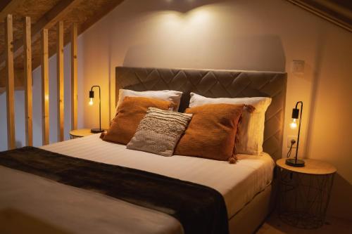 a bedroom with a bed with pillows and two lamps at Retiros do Vale in Vila Real