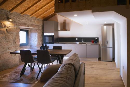 cocina y sala de estar con mesa y sillas en Retiros do Vale, en Vila Real