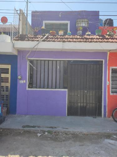 una casa púrpura con una puerta delante de ella en Hostal Maruvillas en Petkanché