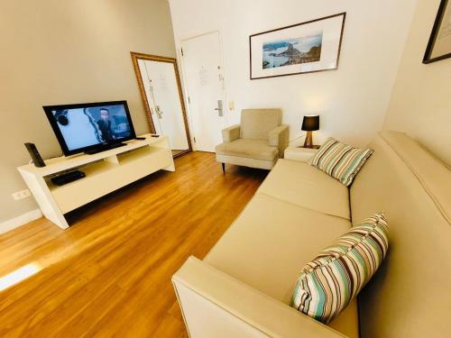 sala de estar con sofá y TV en Top Apart Leblon - com piscina na cobertura, sala de ginastica e garagem, en Río de Janeiro