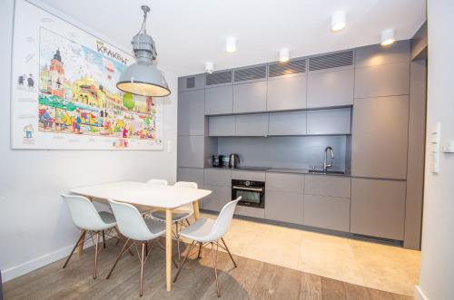 a kitchen with a table and chairs in a room at InPoint Central Apartments in Kraków